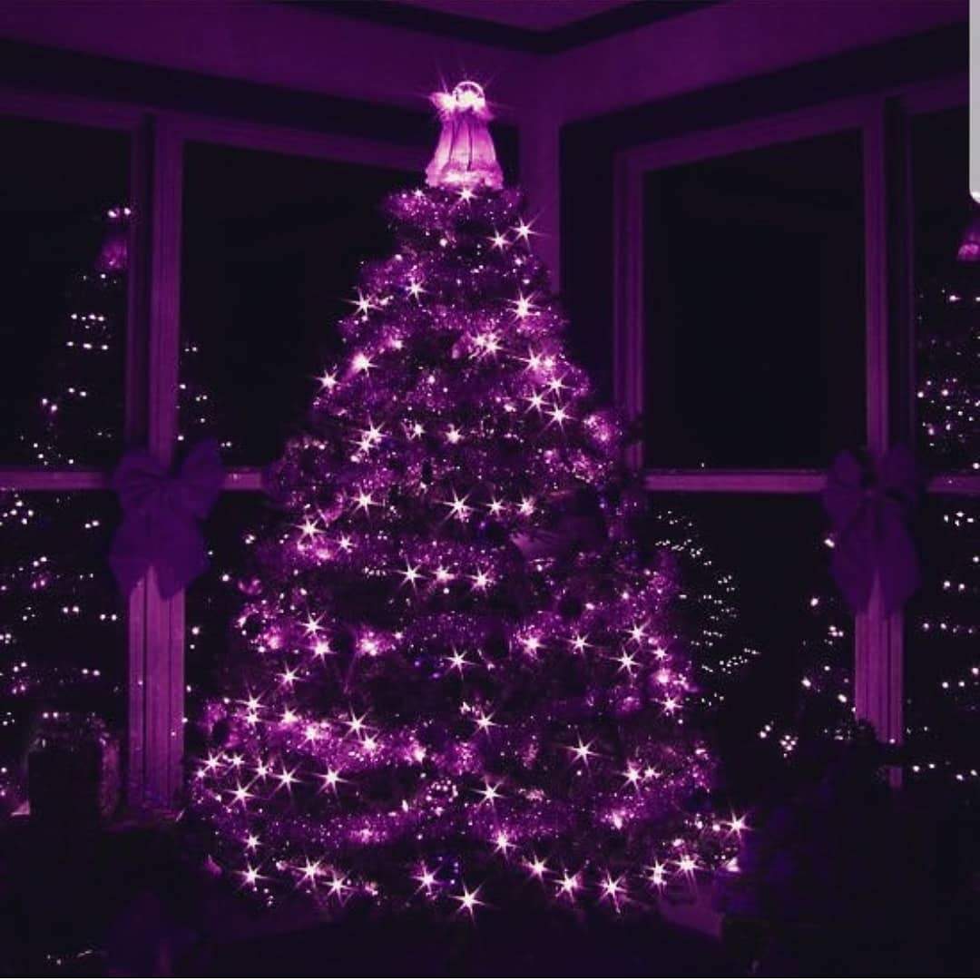 Beautiful purple christmas decorations hanging on christmas tree with shiny  glare Stock Photo by ©Pugovica88 20239083